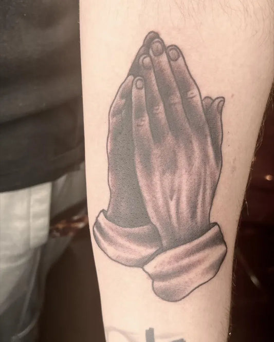 Medium Black and Grey Praying Hands Tattoo on Men Arm by @glasstowntattoo