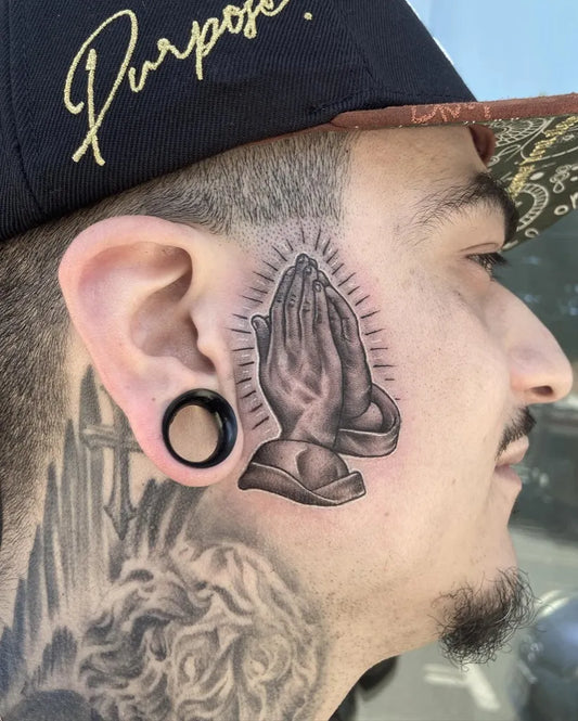 Medium Black and Grey Praying Hands Tattoo on Men Face by @suavecita.gee