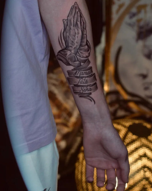 Medium Black and Grey Praying Hands with Banner Tattoo on Men Arm by @bigatattoos