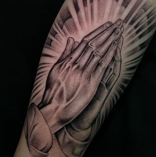 Medium Black and Grey Praying Hands with Rays Tattoo on Men Arm by @staygold.tattoo