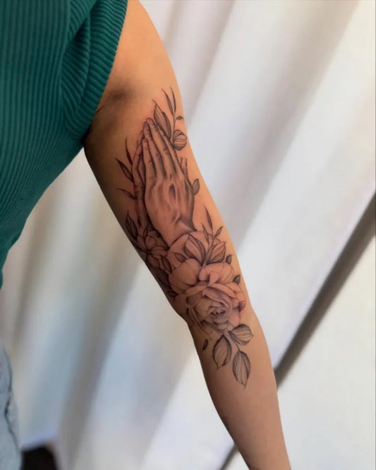 Medium Black and Grey Praying Hands with Roses and Leaves Tattoo on Women Arm by @inkedbyjules_