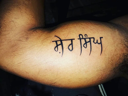 Medium Black and Grey Punjabi Script Tattoo on Men Bicep by @aryan.thapar