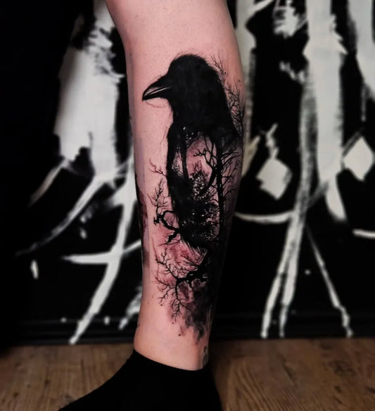 Medium Black and Grey Raven Silhouette with Trees on Women Leg Tattoo by @chris_mandl_tattoo