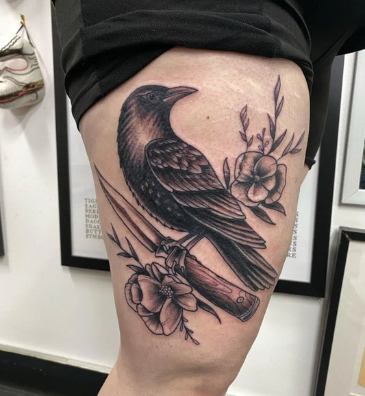 Medium Black and Grey Raven with Knife and Flowers on Women Thigh Tattoo by @kylepearsonart