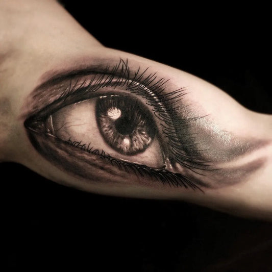 Medium Black and Grey Realism Eye Tattoo on Men Bicep by @dimitar.ink
