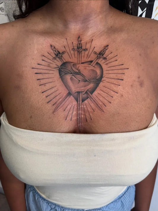 Medium Black and Grey Sacred Heart with Daggers and Rays Tattoo on Women Chest by @blacklambx