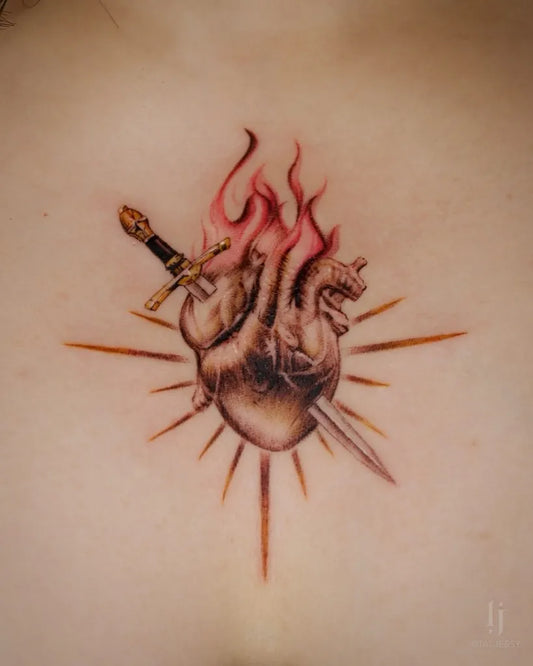 Medium Black and Grey Sacred Heart with Sword and Flames Tattoo on Women Chest by @tat.jessy