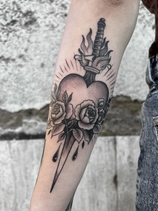 Medium Black and Grey Sacred Heart with Sword and Roses Tattoo on Women Arm by @mixzty.tattoo