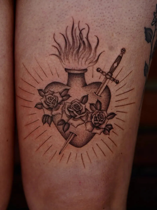 Medium Black and Grey Sacred Heart with Sword and Roses Tattoo on Women Thigh by @brisatattoos