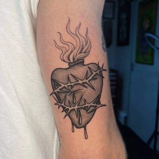 Medium Black and Grey Sacred Heart with Thorns and Flames Tattoo on Men Arm by @paige_bates_tattoos