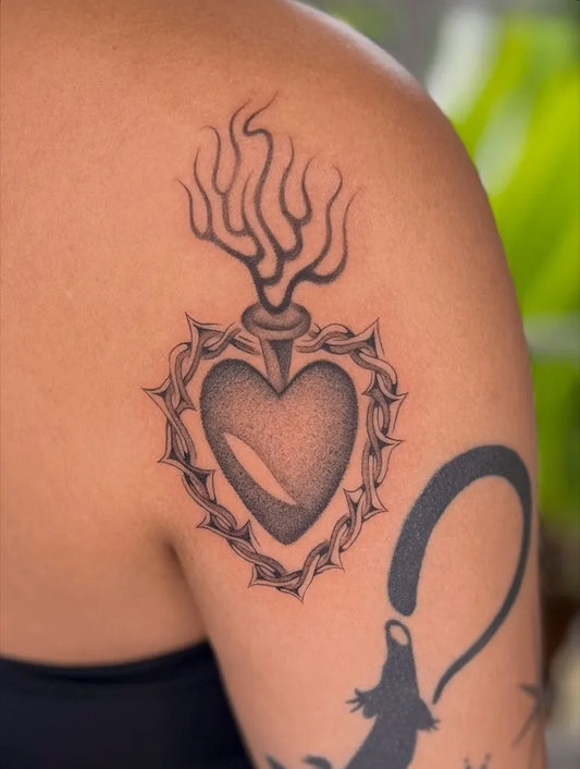 Medium Black and Grey Sacred Heart with Thorns and Flames Tattoo on Women Shoulder by @vessel.work