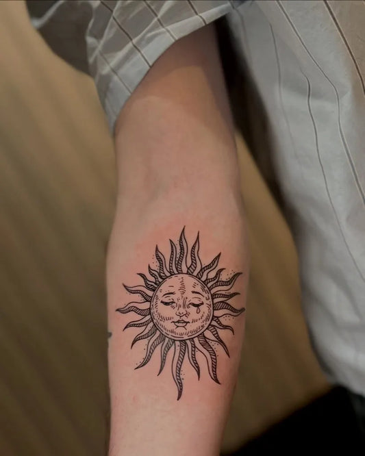 Medium Black and Grey Sad Sun on Women Arm Tattoo by @finelinetattoo.canggu
