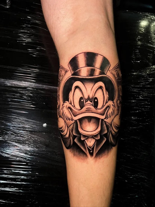 Medium Black and Grey Scrooge McDuck Tattoo on Men Arm by @anestis_ps_tattoo