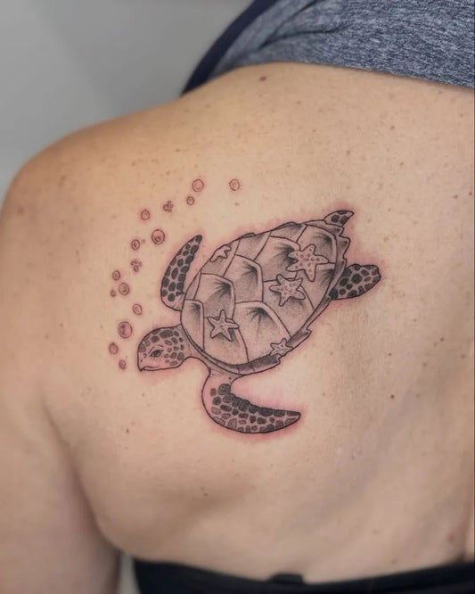 Medium Black and Grey Sea Turtle with Stars and Bubbles Tattoo on Women Shoulder by @visual.thought
