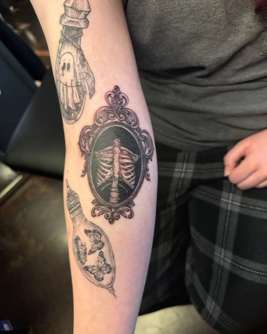 Medium Black and Grey Skeleton Hand Frame Bulb Tattoo on Women Arm by @alexwebbtattoos