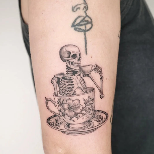 Medium Black and Grey Skeleton in Teacup Tattoo on Women Arm by @captainshade.tt