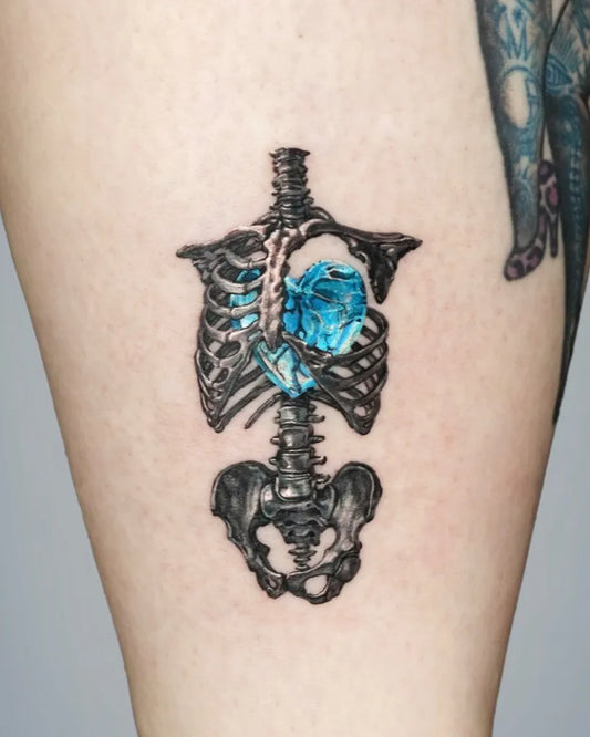 Medium Black and Grey Skeleton with Blue Heart Tattoo on Women Thigh by @orot_tattoo