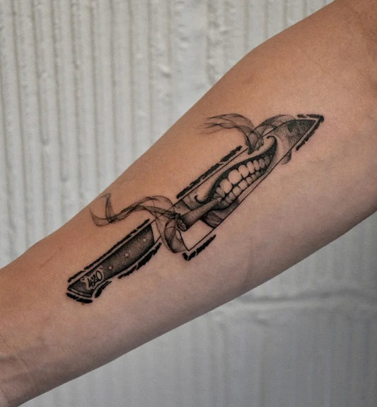 Medium Black and Grey Smiling Knife Tattoo on Men Arm by @gary.tattooer