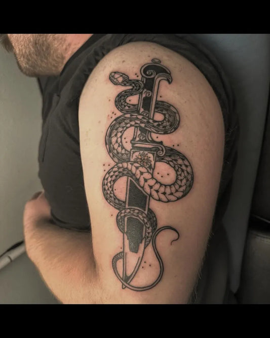 Medium Black and Grey Snake Dagger Tattoo on Men Shoulder by @liv.laeta.tattoo