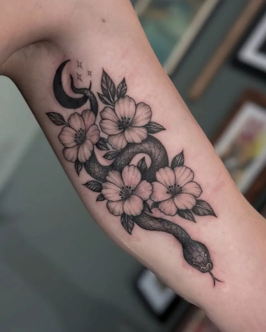 Medium Black and Grey Snake and Flowers Tattoo on Women Bicep by @deadbeat__steve