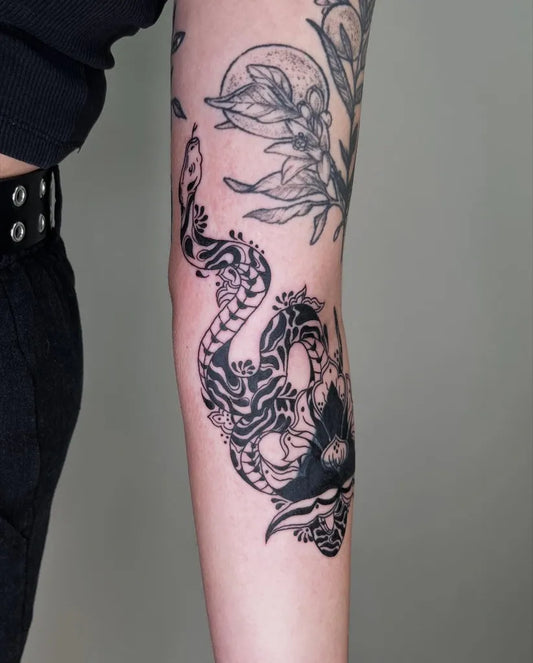Medium Black and Grey Snake and Flowers Tattoo on Women Inner Arm by @blushpuppytattoos