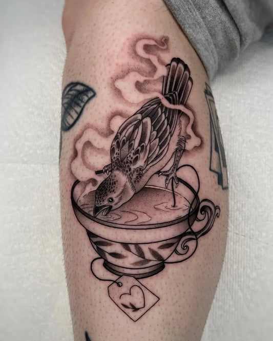 Medium Black and Grey Sparrow Teacup Tattoo on Women Leg by @tattsmin