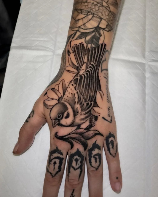 Medium Black and Grey Sparrow and Flowers Tattoo on Men Hand by @tattoosbysonja