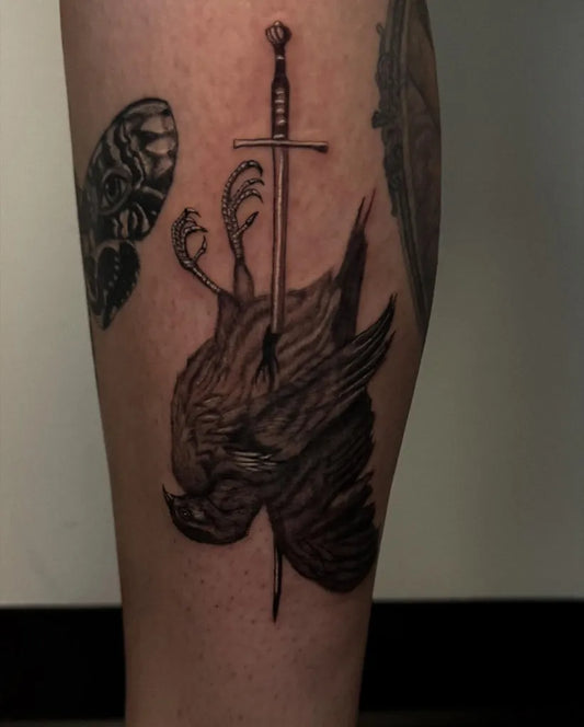 Medium Black and Grey Sparrow on Sword Men Leg by @davidp_tattoos
