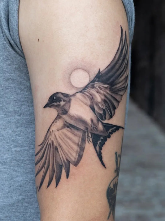 Medium Black and Grey Sparrow with Sun Tattoo on Men Arm by @isabelroseink