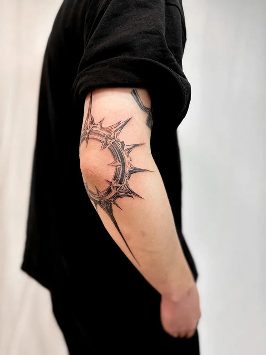 Medium Black and Grey Spiked Crown Tattoo on Men Arm by @petersteffensen