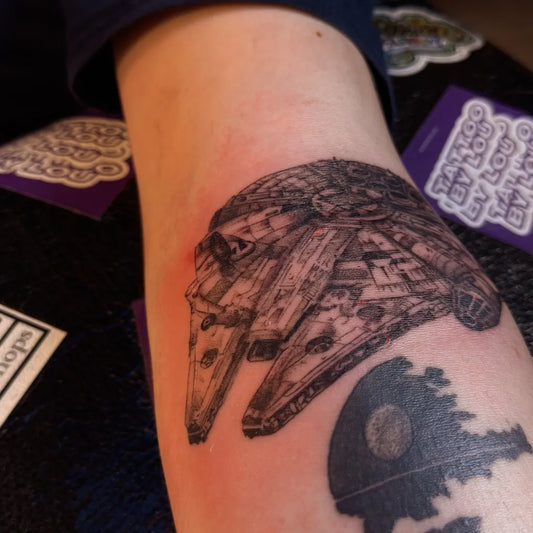 Medium Black and Grey Star Wars Millennium Falcon and Death Star Tattoo on Men Arm by @tattoo.by.lou