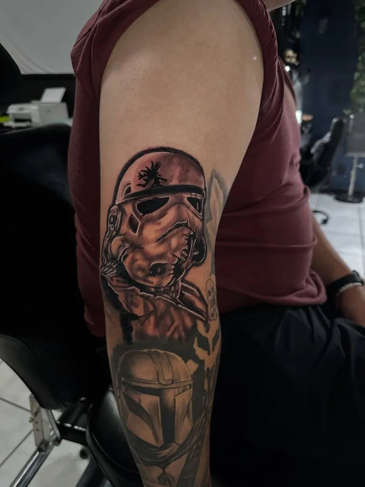 Medium Black and Grey Star Wars Stormtrooper and Mandalorian Tattoo on Men Arm by @roxy_trocar_tattoo
