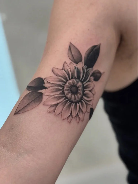 Medium Black and Grey Sunflower and Leaves on Women Arm Tattoo by @tattooist_kyo