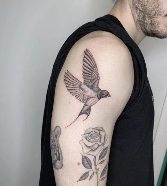 Medium Black and Grey Swallow and Rose Tattoo on Men Shoulder by @sailorstattoomilanoduomo