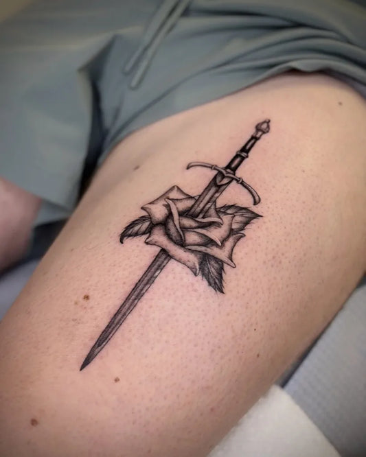 Medium Black and Grey Sword and Rose on Women Thigh Tattoo by @mind7_tattoo