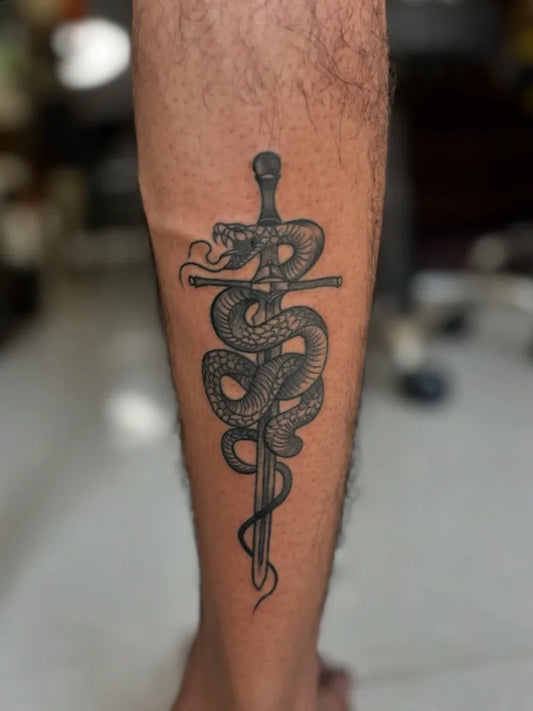 Medium Black and Grey Sword and Snake Tattoo on Men Leg by @kabirainktattooandpiercing