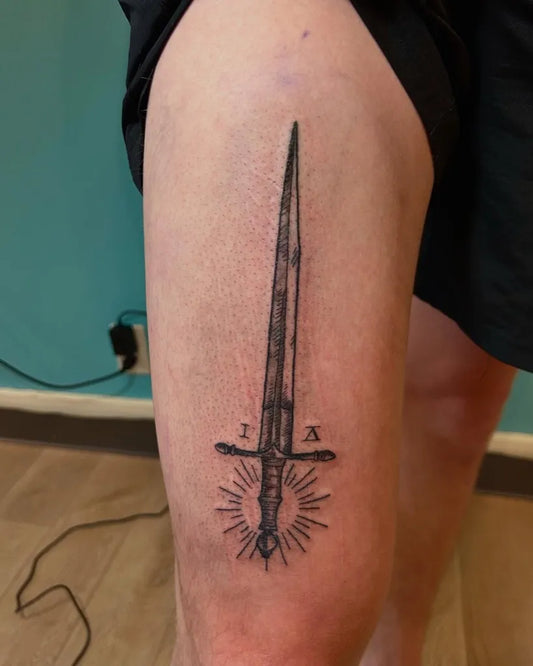 Medium Black and Grey Sword with Radiant Crossguard on Men Thigh Tattoo by @eiribubbles_tattoos