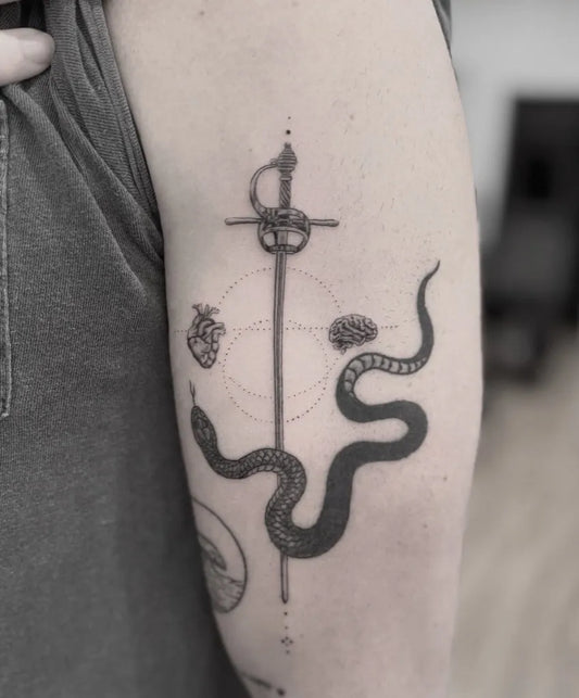 Medium Black and Grey Sword with Snakes and Heart on Women Arm Tattoo by @cihanpohrenk