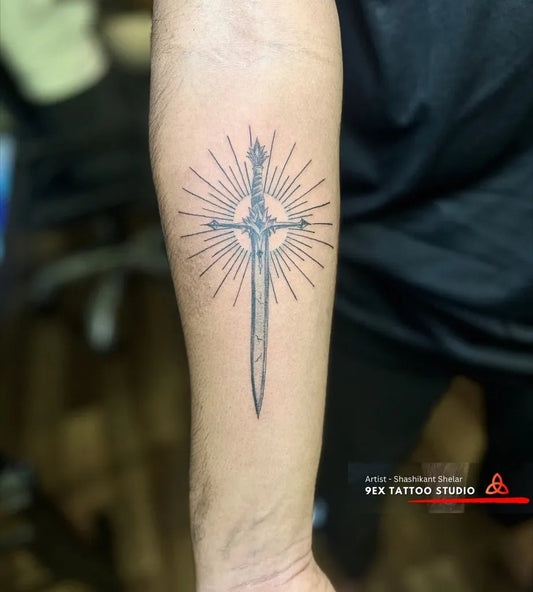 Medium Black and Grey Sword with Sunburst on Men Arm Tattoo by @9extattooindia