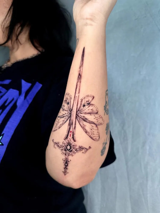 Medium Black and Grey Sword with Wings and Ornamental Guard on Women Forearm Tattoo by @inchiostrocuore