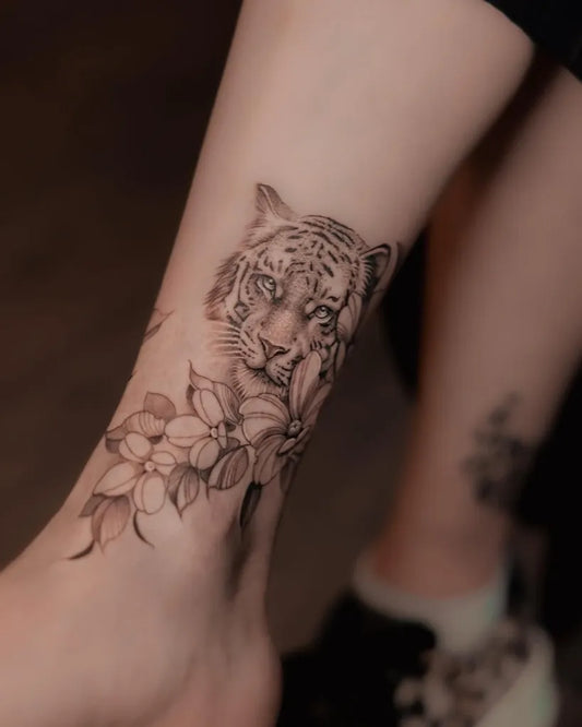 Medium Black and Grey Tiger and Flowers on Women Leg Tattoo by @lucatattoo.ar