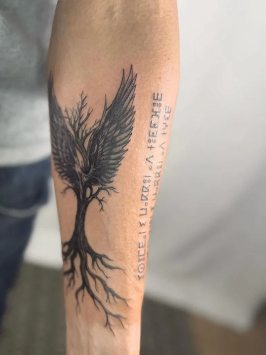 Medium Black and Grey Tree with Wings and Text Tattoo on Men Arm by @amelie.catleya.tattoo