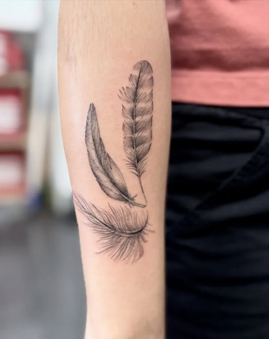 Medium Black and Grey Two Feathers Tattoo on Women Forearm by @otqt_dailytatts