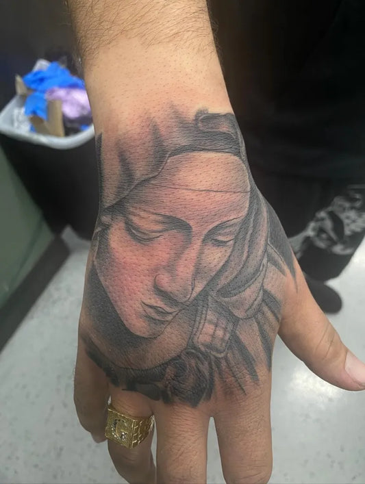 Medium Black and Grey Virgin Mary Tattoo on Men Hand by @tattoosby.psychic