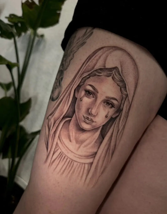 Medium Black and Grey Virgin Mary with Tears Tattoo on Women Thigh by @alyanna.ink