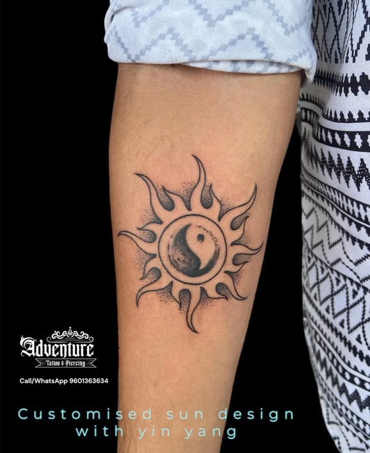 Medium Black and Grey Yin Yang Sun Tattoo on Men Arm by @adventure_tattoo_ahmedabad