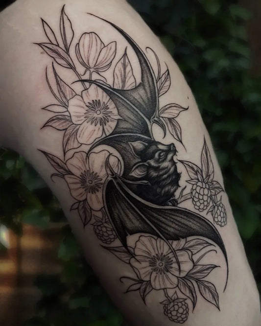 Medium Blackwork Bat Flowers Tattoo on Women Thigh by @fabledhand.tattoo