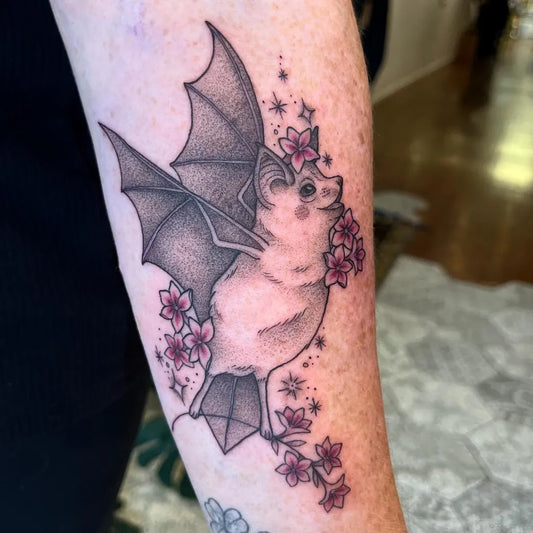 Medium Blackwork Bat with Cherry Blossoms Tattoo on Women Arm by @tattoodlidani