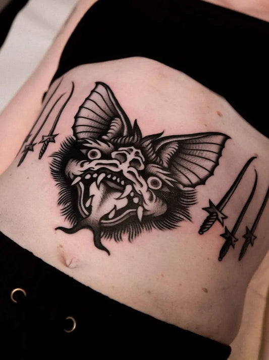 Medium Blackwork Bat with Daggers Tattoo on Women Abdomen by @chirima_blk