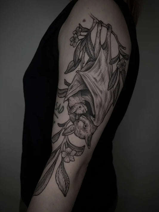 Medium Blackwork Bat with Flowers Tattoo on Women Arm by @ashandwood